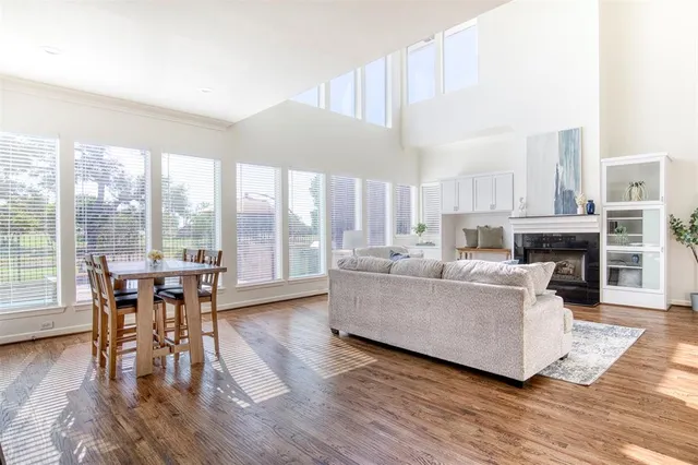 a kitchen with stainless steel appliances granite countertop a table chairs stove and wooden floor