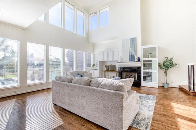 a living room with furniture a large window and wooden floor