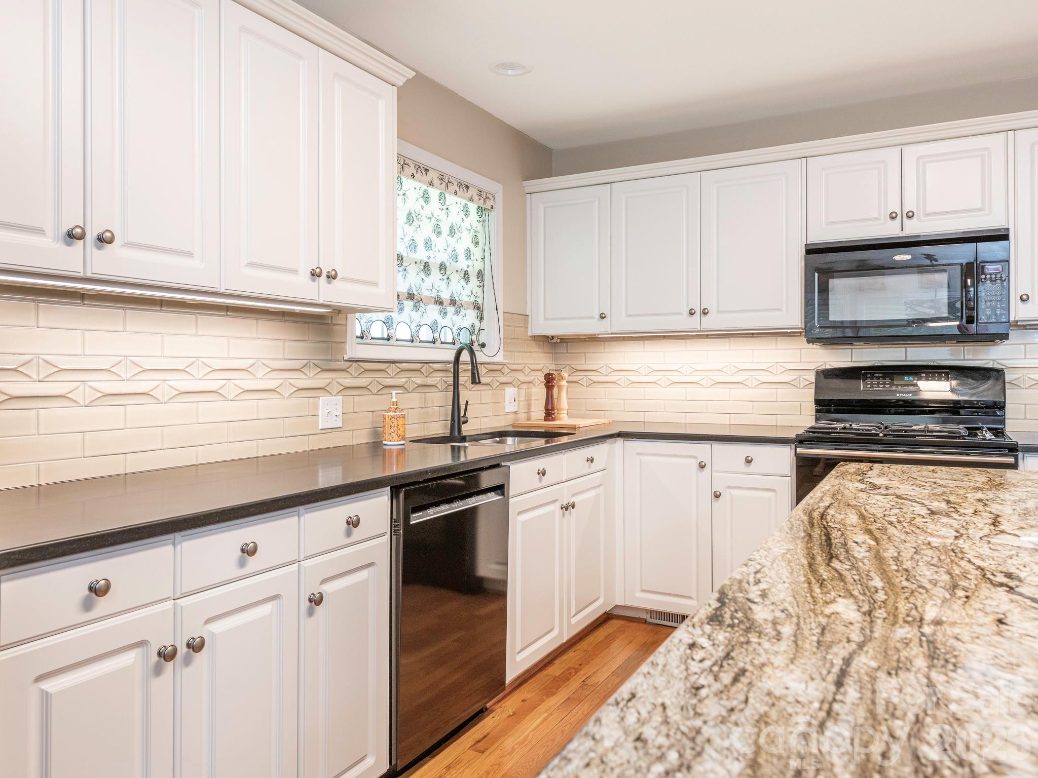 4440 Hucks Road Charlotte, NC 28269 - Photo 14 of 45 a kitchen with granite countertop white cabinets and stainless steel appliances