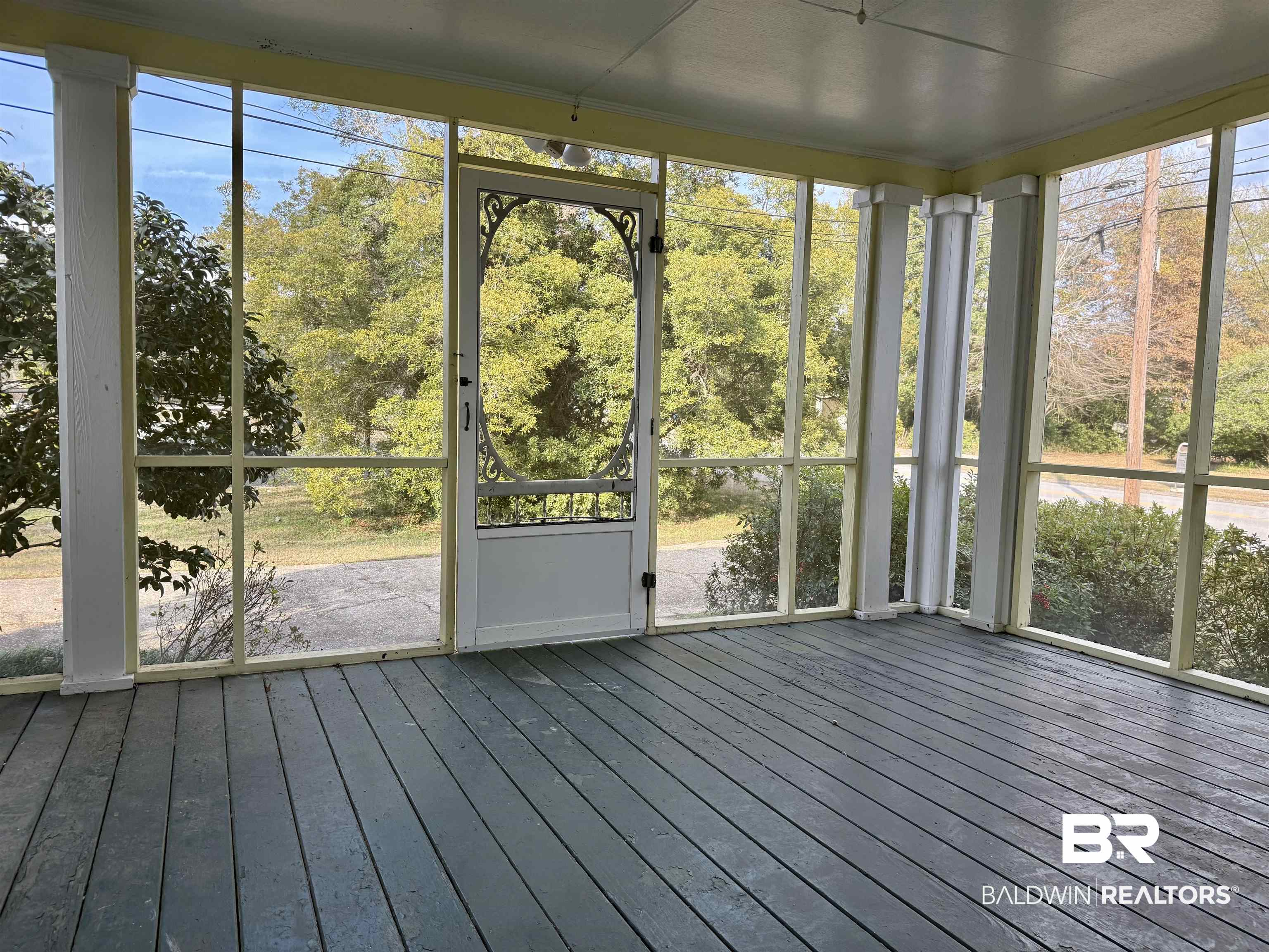 423 Evergreen Avenue Brewton, AL 36426 - Photo 2 of 18 Unfurnished sunroom featuring healthy amount of natural light and view of scattered trees