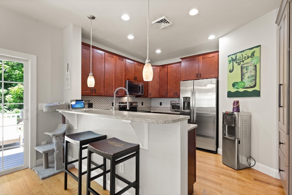 284 Maple Street, Unit 284 Middleton, MA 01949 - Photo 12 of 30 a kitchen with refrigerator cabinets and a table