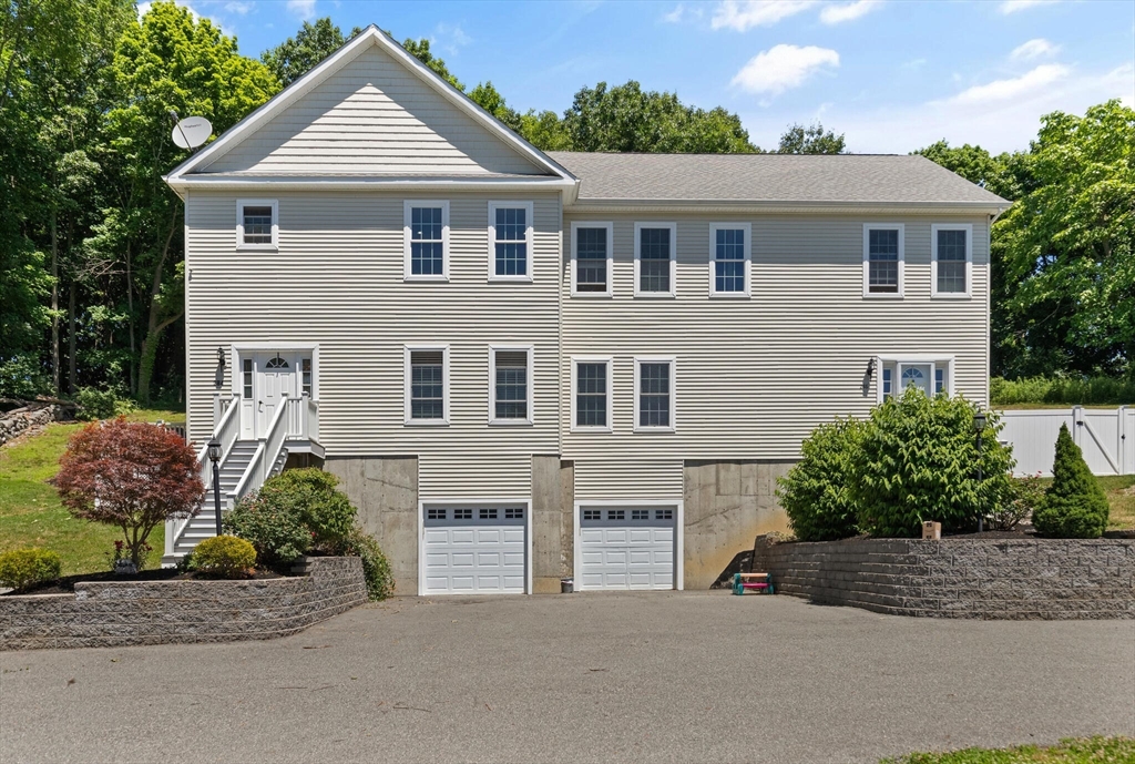 284 Maple Street, Unit 284 Middleton, MA 01949 - Photo 2 of 30 a front view of a house with a yard and garage