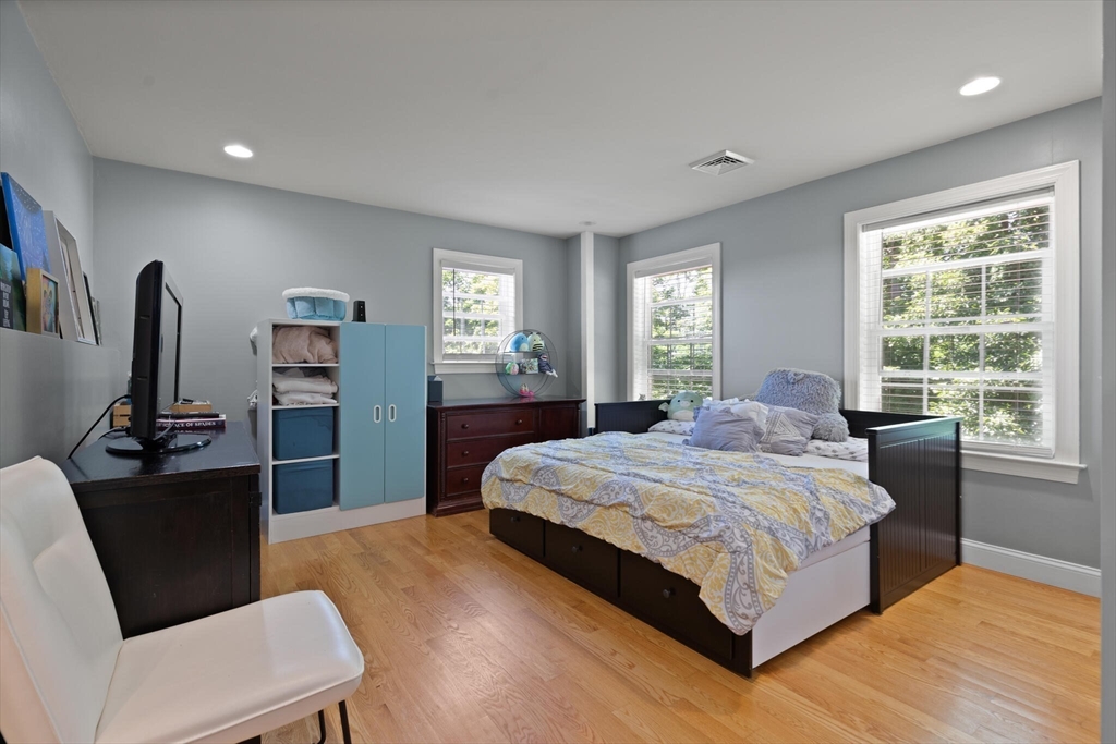 284 Maple Street, Unit 284 Middleton, MA 01949 - Photo 21 of 30 a bedroom with a bed and a flat screen television