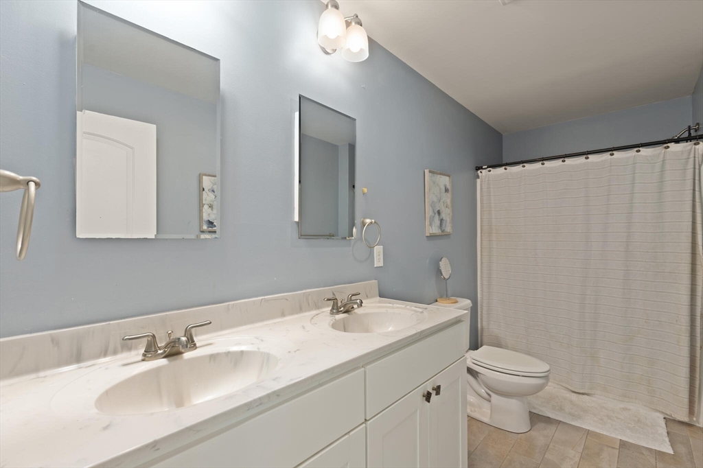 284 Maple Street, Unit 284 Middleton, MA 01949 - Photo 22 of 30 a bathroom with a granite countertop sink a toilet and a mirror