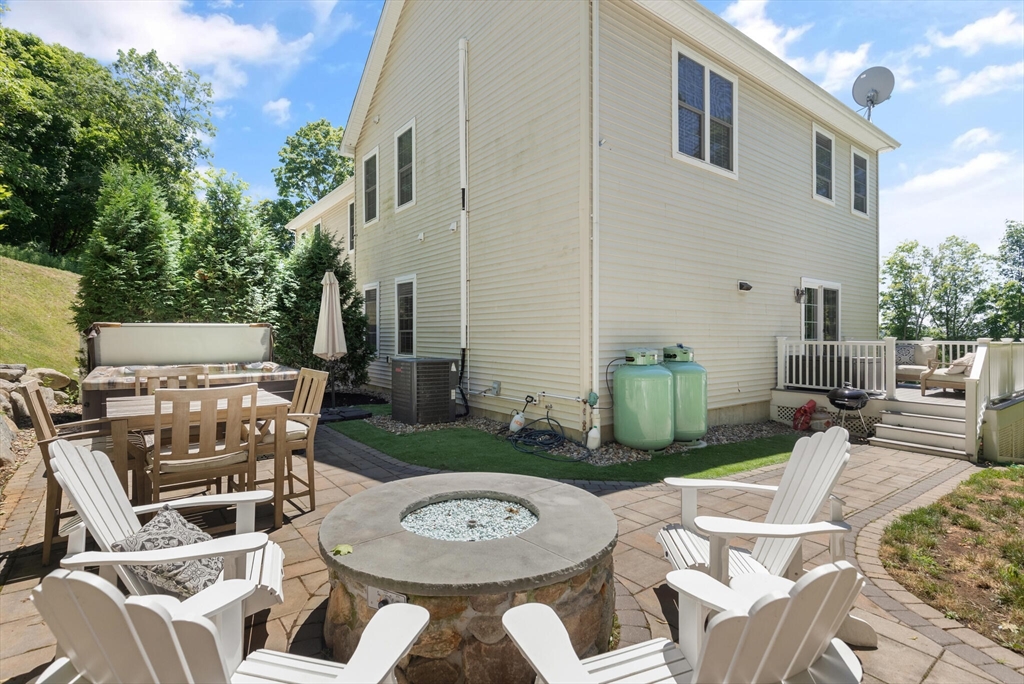284 Maple Street, Unit 284 Middleton, MA 01949 - Photo 27 of 30 a view of a patio with couches table and chairs with potted plants and a fire pit