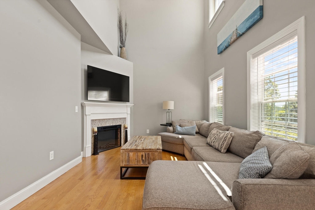 284 Maple Street, Unit 284 Middleton, MA 01949 - Photo 5 of 30 a living room with furniture a fireplace and a flat screen tv