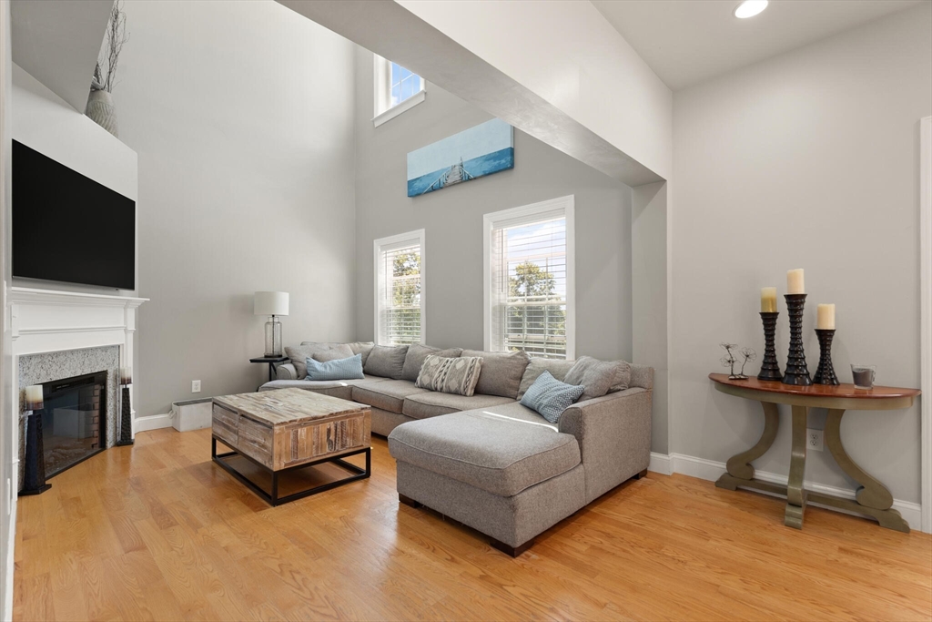 284 Maple Street, Unit 284 Middleton, MA 01949 - Photo 7 of 30 a living room with furniture and a fireplace
