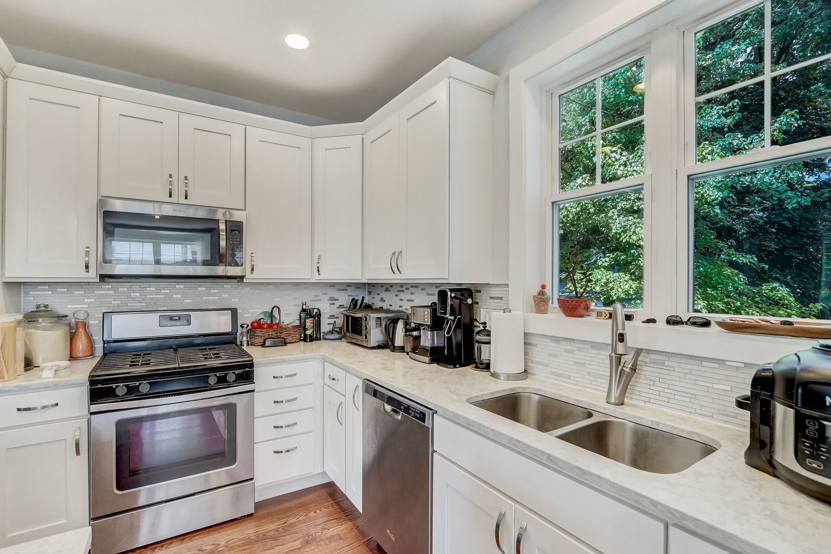 204 Fairbank Road Riverside, IL 60546 - Photo 7 of 35 a kitchen with white cabinets a sink and a stove with wooden floor
