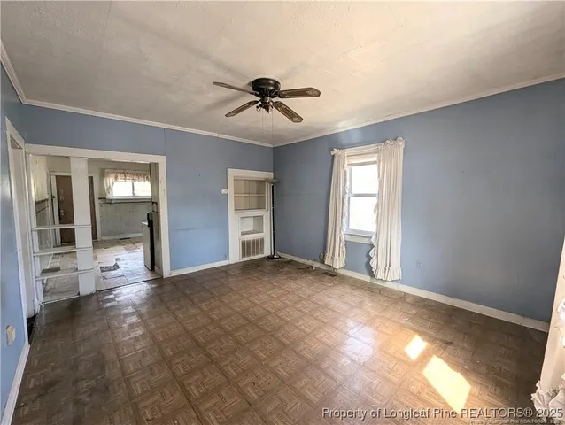 a view of a big room with windows and chandelier fan