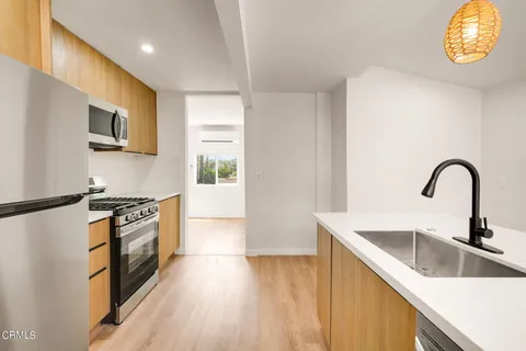 a kitchen with granite countertop a stove a sink and a microwave