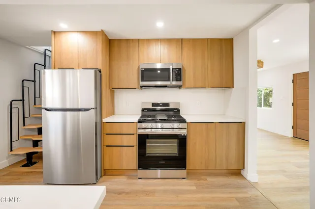 a kitchen with stainless steel appliances granite countertop a refrigerator stove and microwave