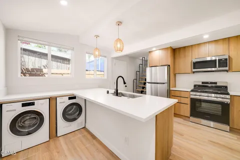 a kitchen with kitchen island a stove and a sink