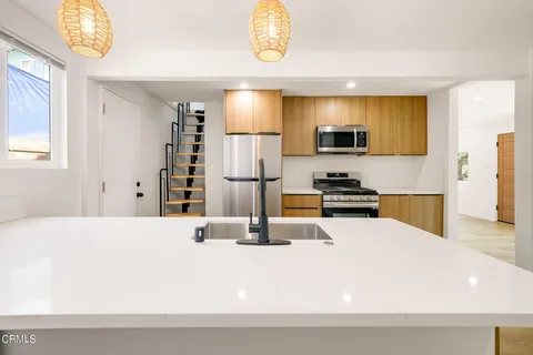 a kitchen with stainless steel appliances kitchen island granite countertop a refrigerator and a stove top oven