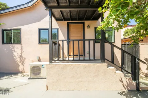 a view of a balcony with floor to ceiling window and tree