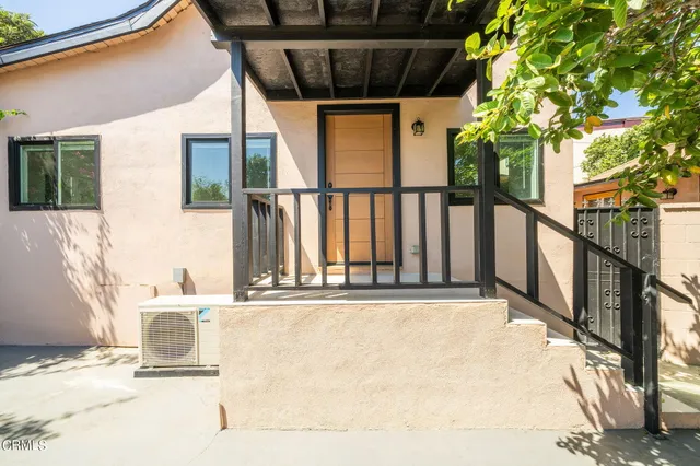 a view of a balcony with floor to ceiling window and tree