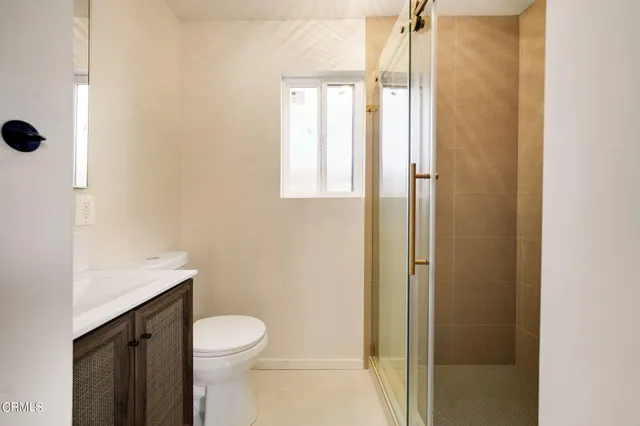 a bathroom with a granite countertop toilet a sink and a mirror