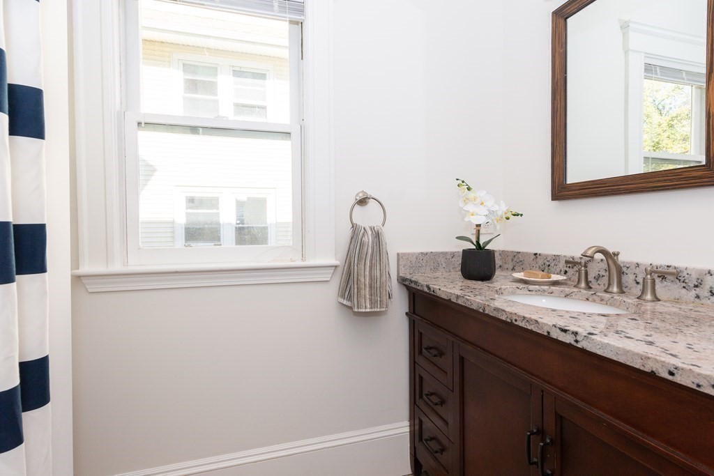 9 Trowbridge Street Arlington, MA 02474 - Photo 18 of 22 a bathroom with a granite countertop sink and a mirror