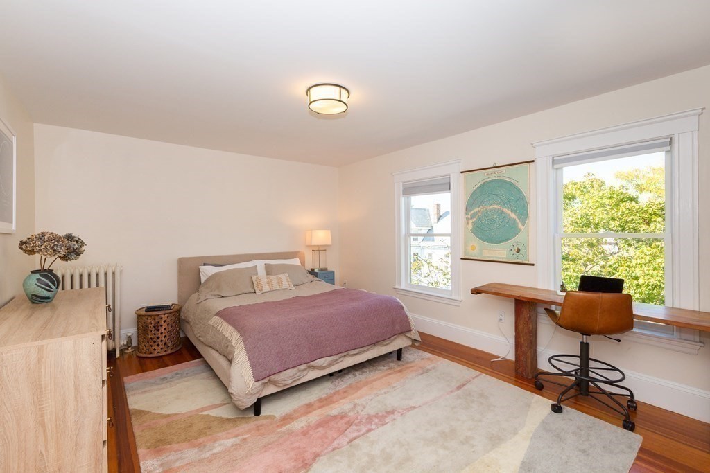 9 Trowbridge Street Arlington, MA 02474 - Photo 7 of 22 a bedroom with a bed a table and windows