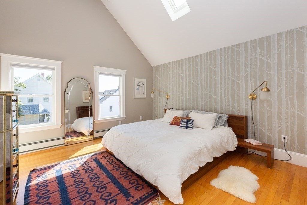 9 Trowbridge Street Arlington, MA 02474 - Photo 10 of 22 a bedroom with a bed a lamp on dresser and a large window