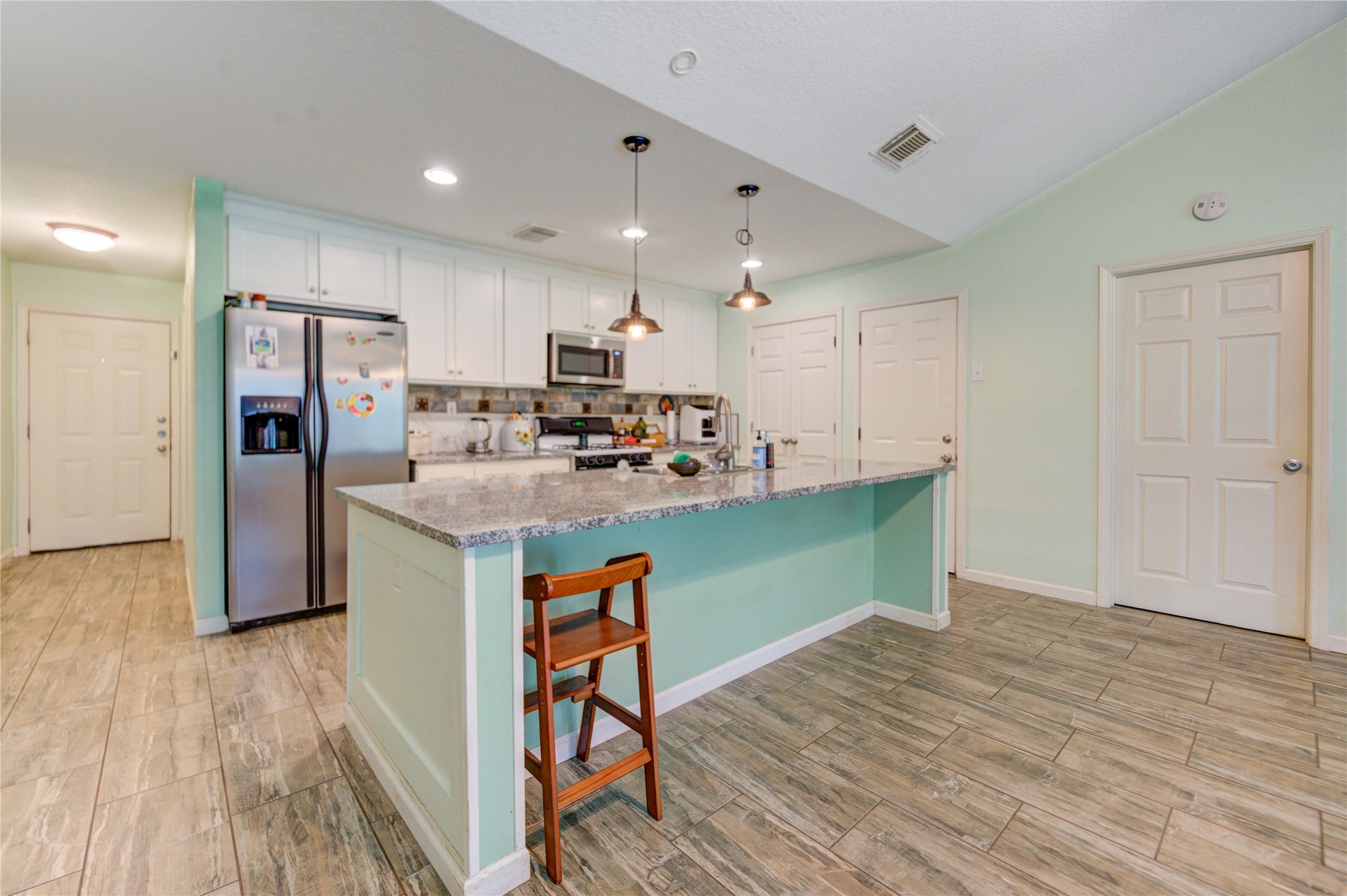 3530 Kentwood Drive Spring, TX 77380 - Photo 16 of 37 a kitchen with kitchen island wooden floors appliances and cabinets