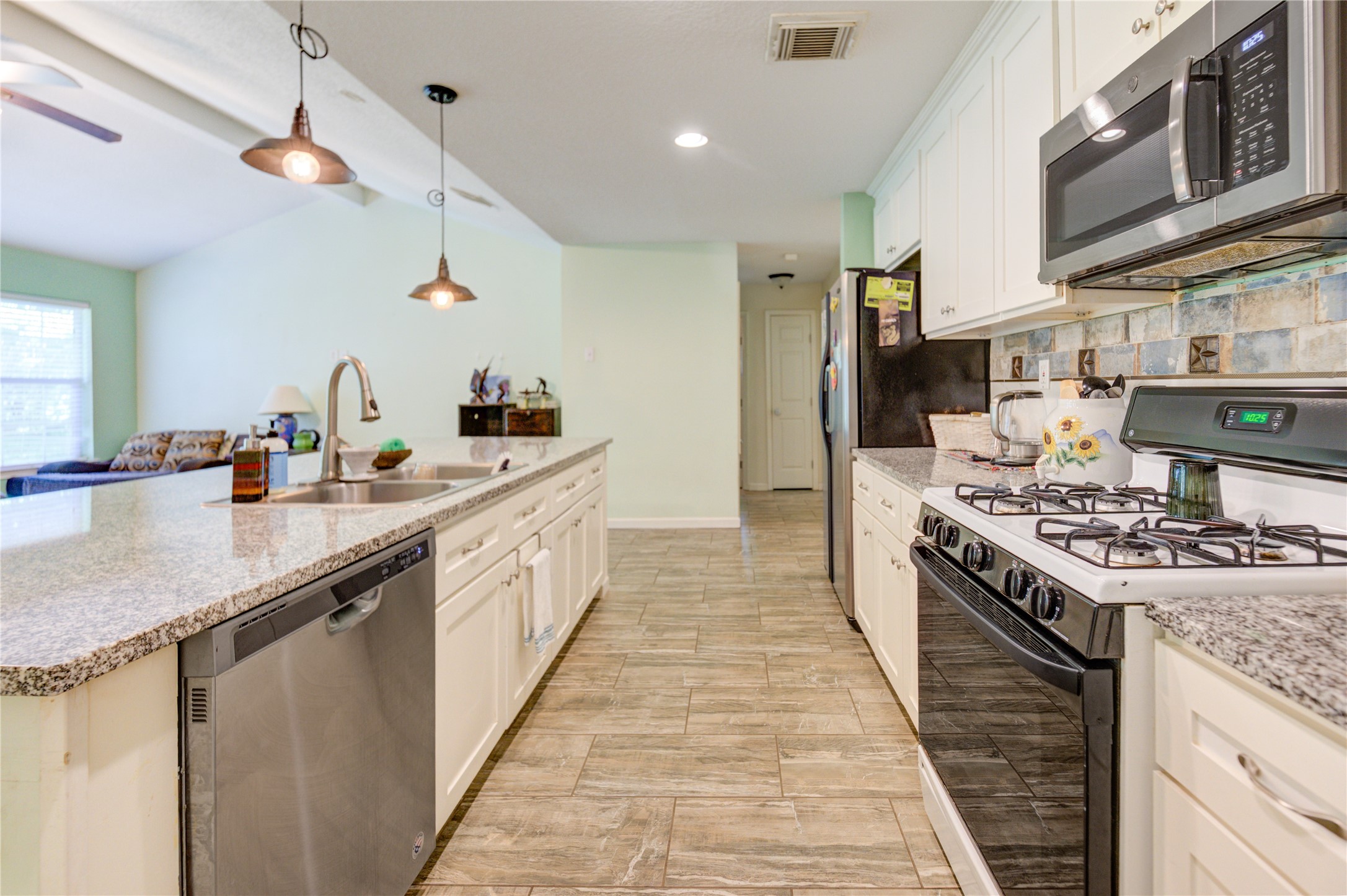 3530 Kentwood Drive Spring, TX 77380 - Photo 19 of 37 a large kitchen with stainless steel appliances granite countertop a stove and a sink