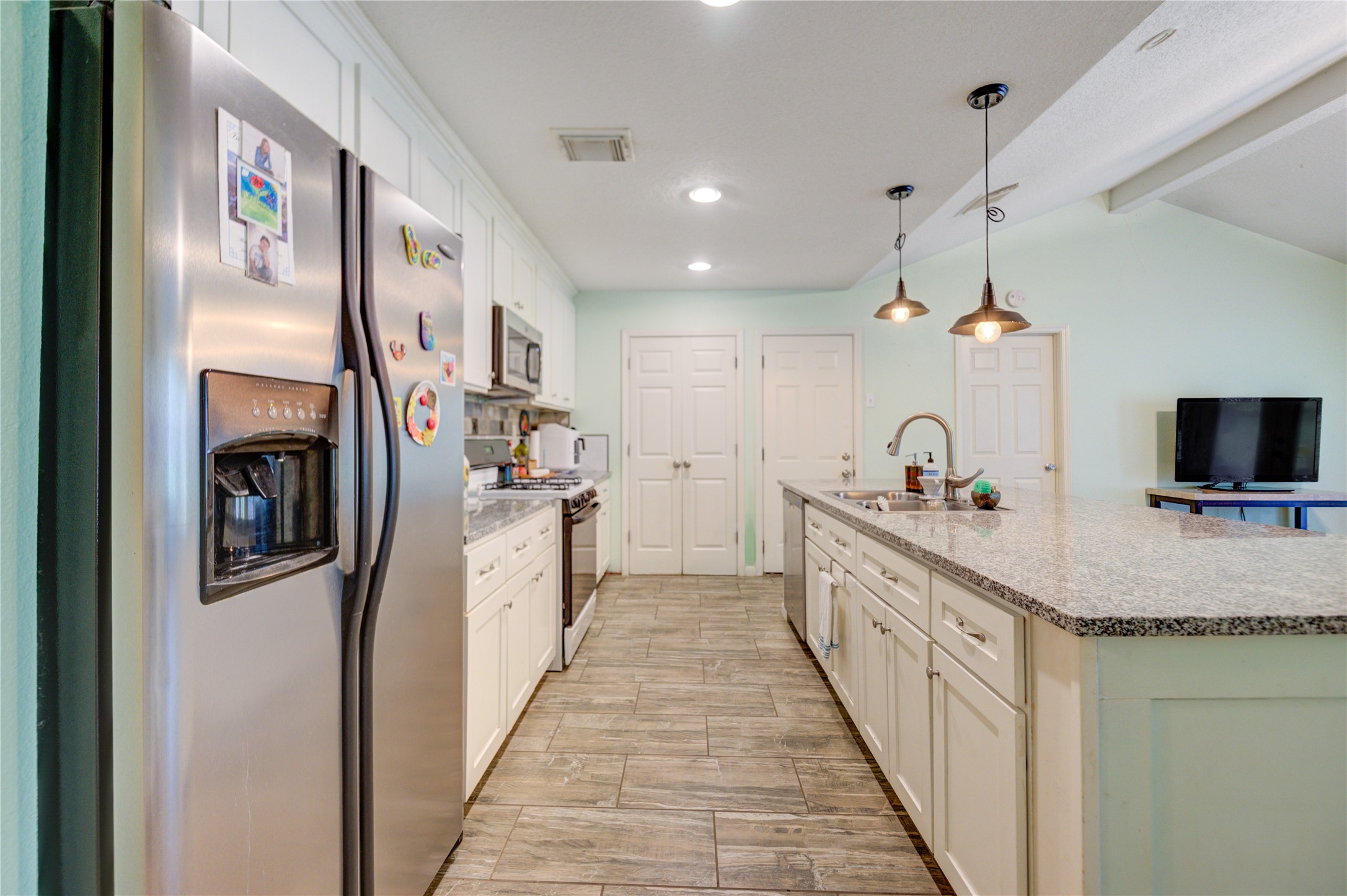 3530 Kentwood Drive Spring, TX 77380 - Photo 22 of 37 a open kitchen with kitchen island granite countertop a sink and refrigerator