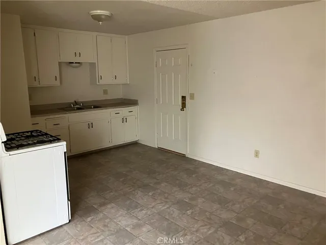 a kitchen with a stove and white cabinets