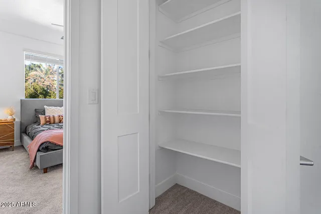 a large bed sitting in a room next to a window