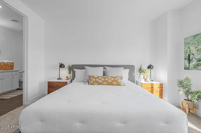 a bedroom with a bed and a potted plant