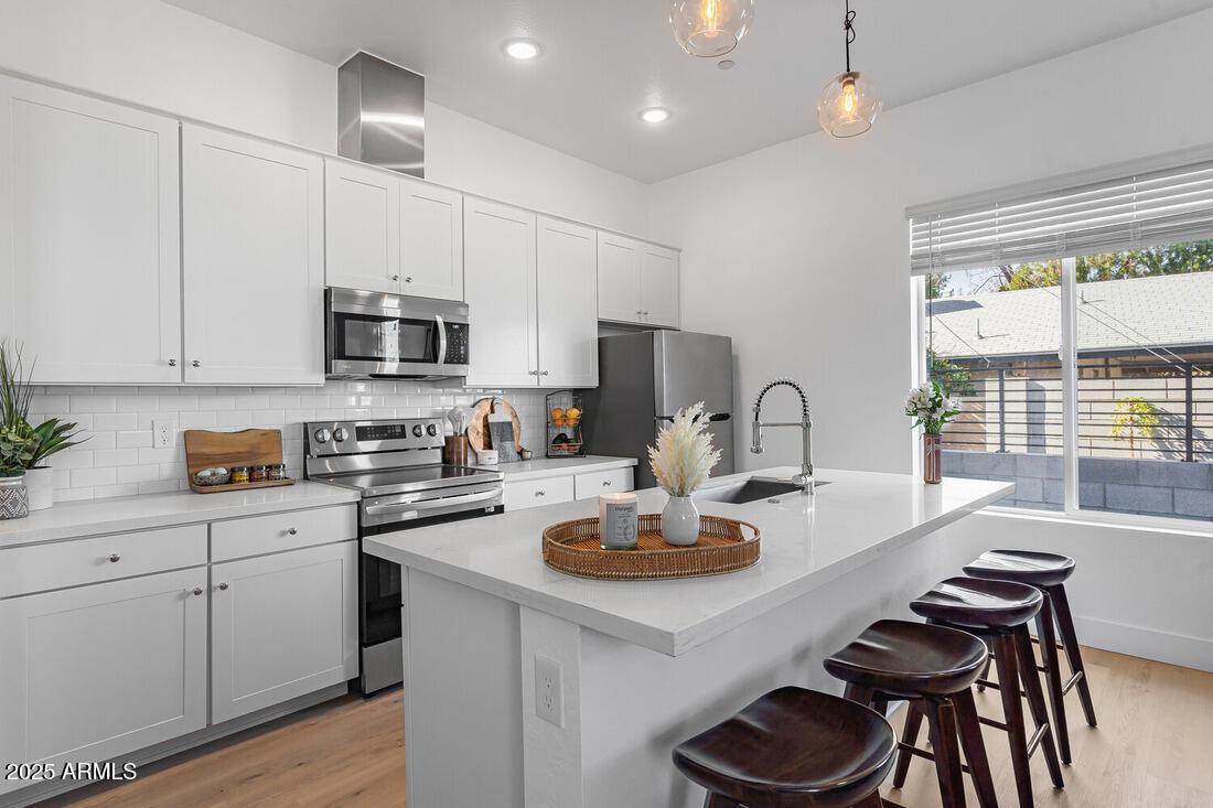 1247 East Colter Street, Unit 1 Phoenix, AZ 85014 - Photo 3 of 32 a kitchen with sink a microwave and cabinets