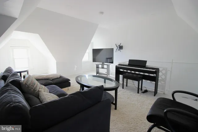 a living room with furniture and a piano