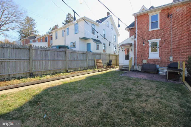 a view of a white house in the back yard