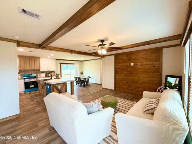 a living room with furniture and kitchen view