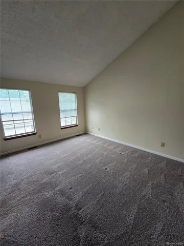 an empty room with windows and brick walls