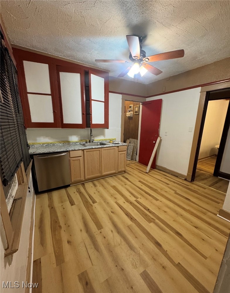 12406 Kinsman Road Cleveland, OH 44120 - Photo 6 of 29 Kitchen with light countertops, stainless steel dishwasher, a textured ceiling, light wood-type flooring, and a ceiling fan