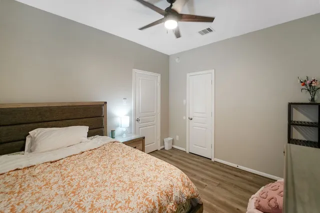 a bedroom with a bed and a ceiling fan