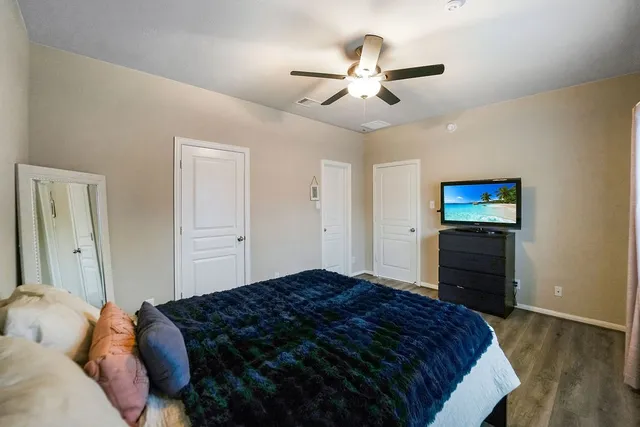 a bedroom with a bed and a ceiling fan