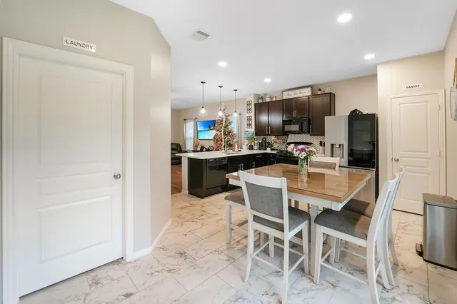 a dining area with stainless steel appliances a refrigerator and microwave