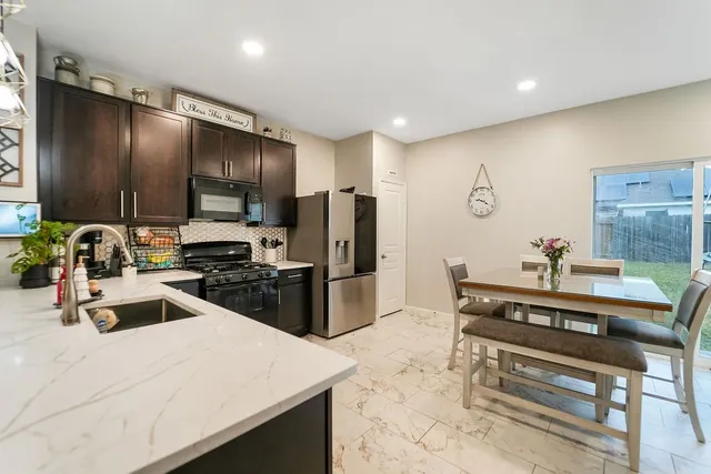 a kitchen with stainless steel appliances a refrigerator and a stove top oven
