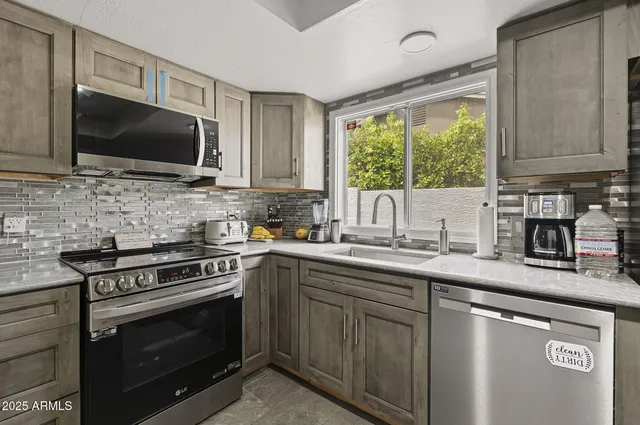 a kitchen with stainless steel appliances a stove sink microwave and cabinets