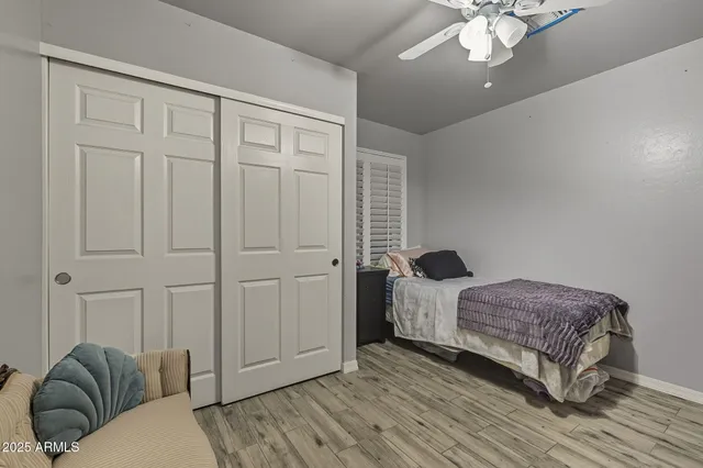 a bedroom with a bed and wooden floor