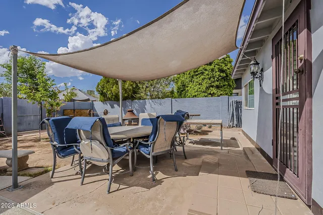 a view of patio with table and chairs and potted plants