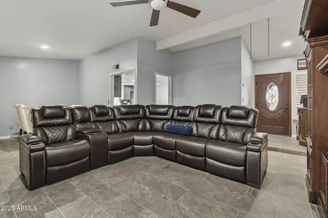 a living room with a couch and a ceiling fan