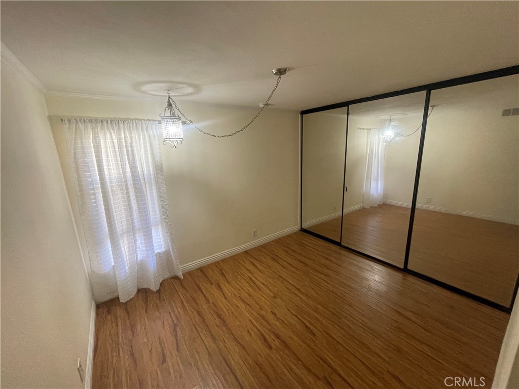 124 Tangelo, Unit 390 Irvine, CA 92618 - Photo 8 of 9 an empty room with wooden floor and windows