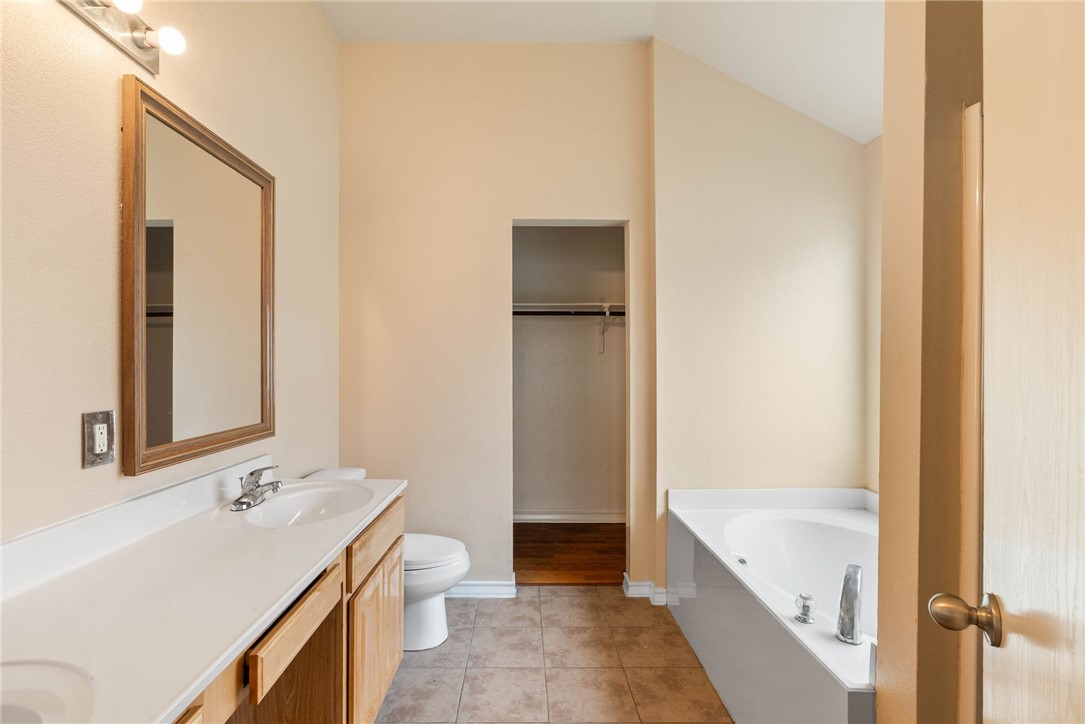 6606 Riding Wind Drive Corpus Christi, TX 78414 - Photo 8 of 15 a bathroom with a tub sink and mirror