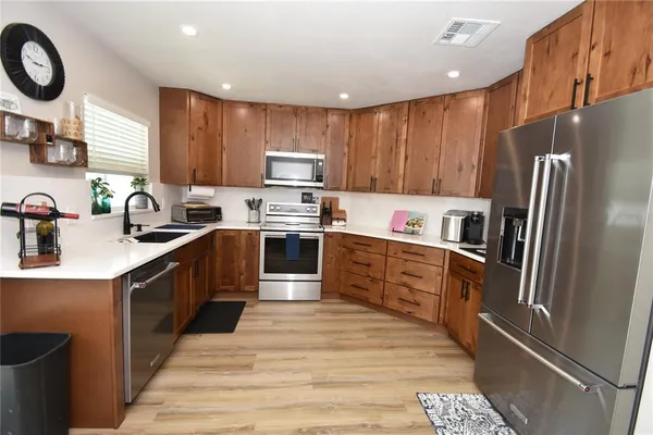 a kitchen with stainless steel appliances a refrigerator sink and cabinets