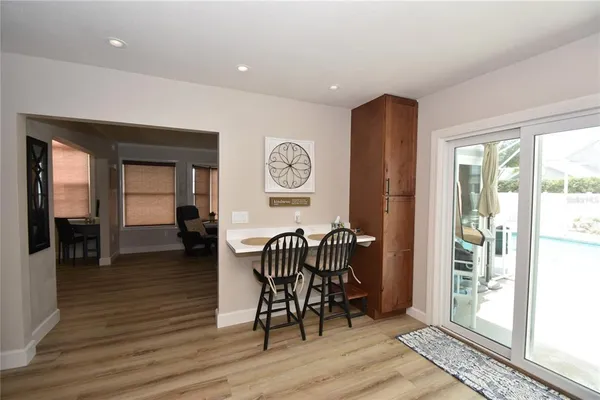 a dining room with furniture wooden floor a rug and a chandelier