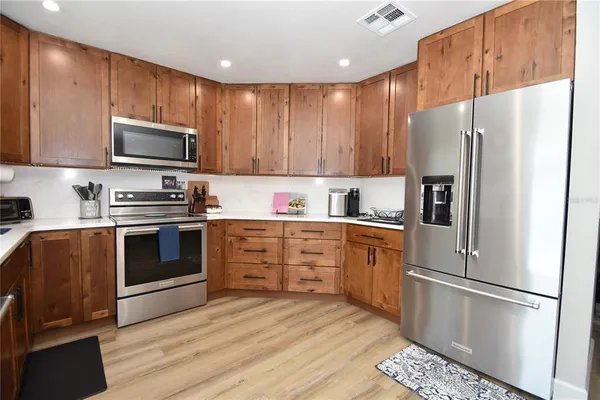 a kitchen with stainless steel appliances a refrigerator sink and microwave
