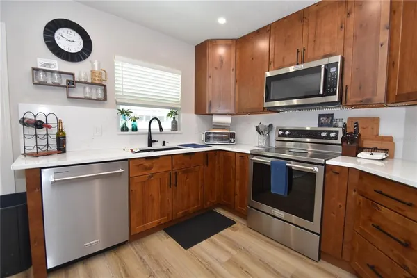 a kitchen with stainless steel appliances a sink a stove a microwave and cabinets