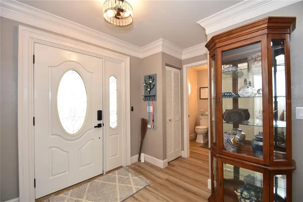 a view of a hallway with wooden floor and a dining room